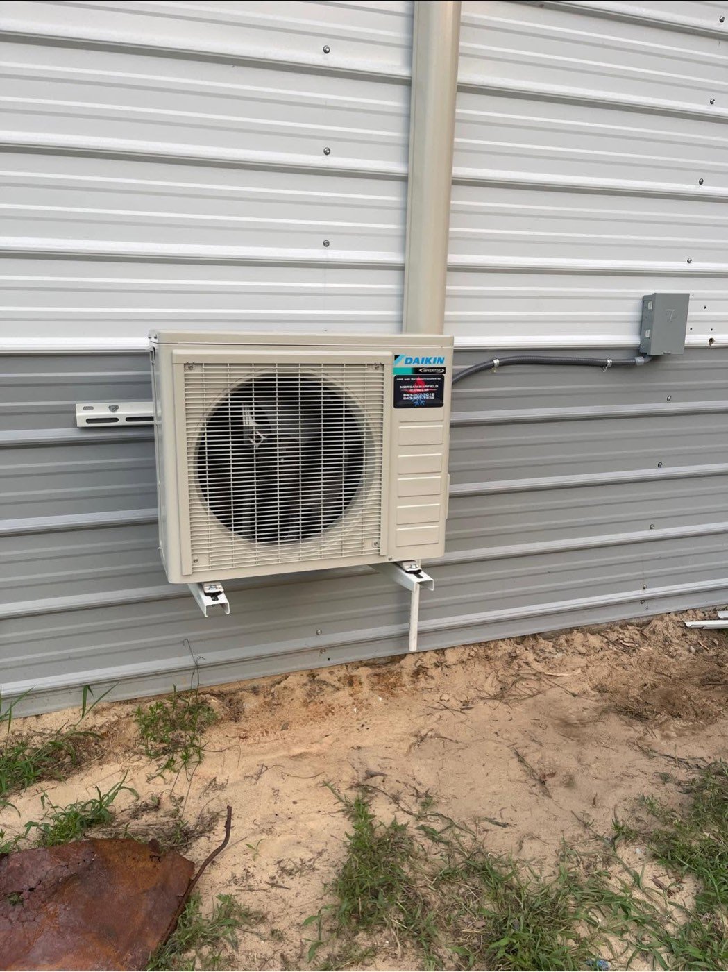 Daikin ductless mini-split condenser mounted on a metal building exterior
